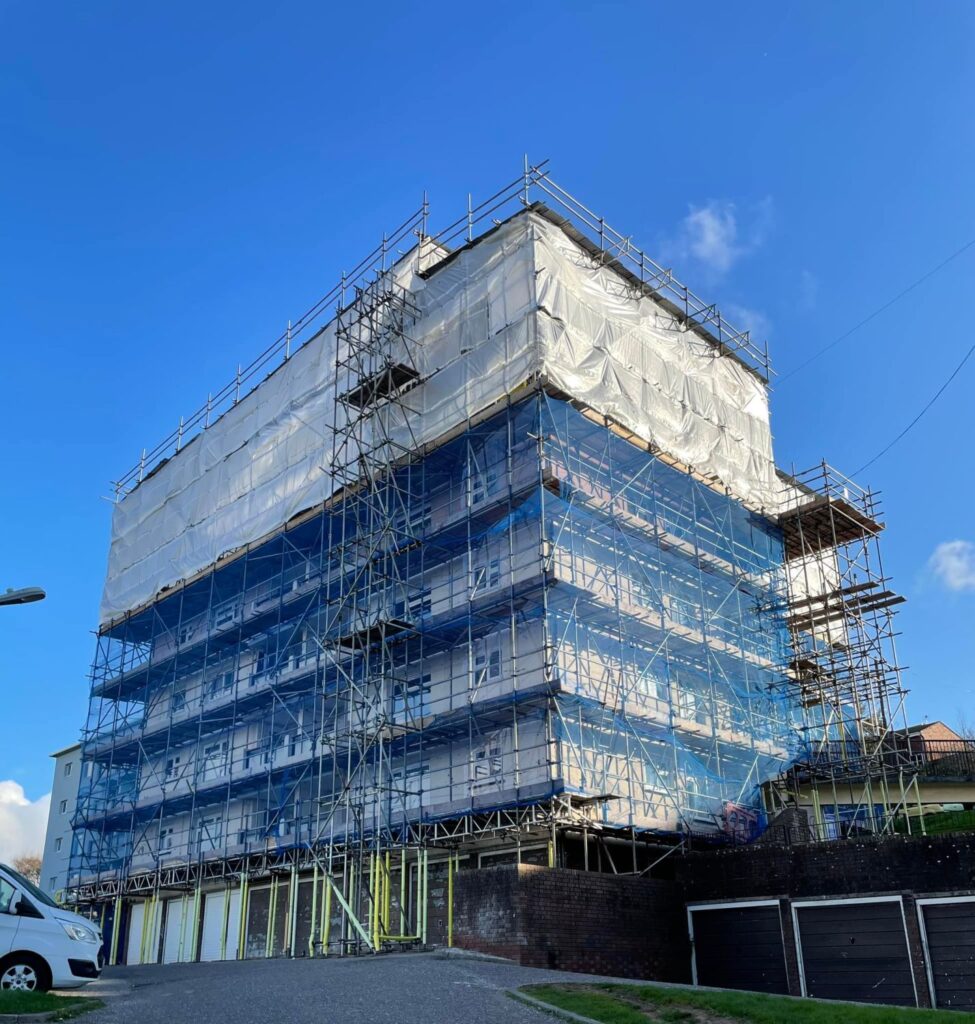 Looking from the ground up at Cavity wall insulation extraction on the second block of flats in Teignmouth CAVIVAC removal of defective insulation material